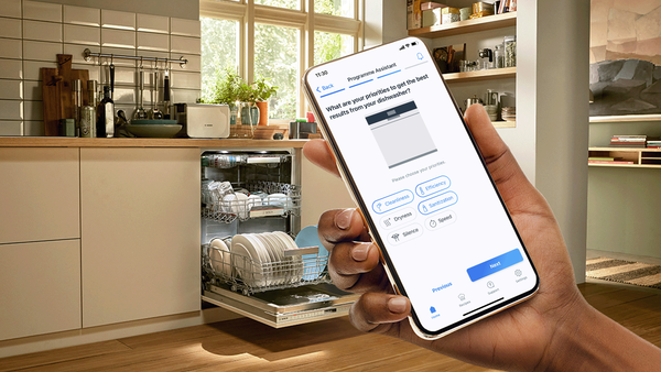 Hand controlling a Bosch dishwasher through the Home Connect app