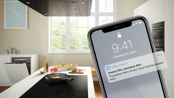 Phone showing the Home Connect app next to a Bosch hob and hood